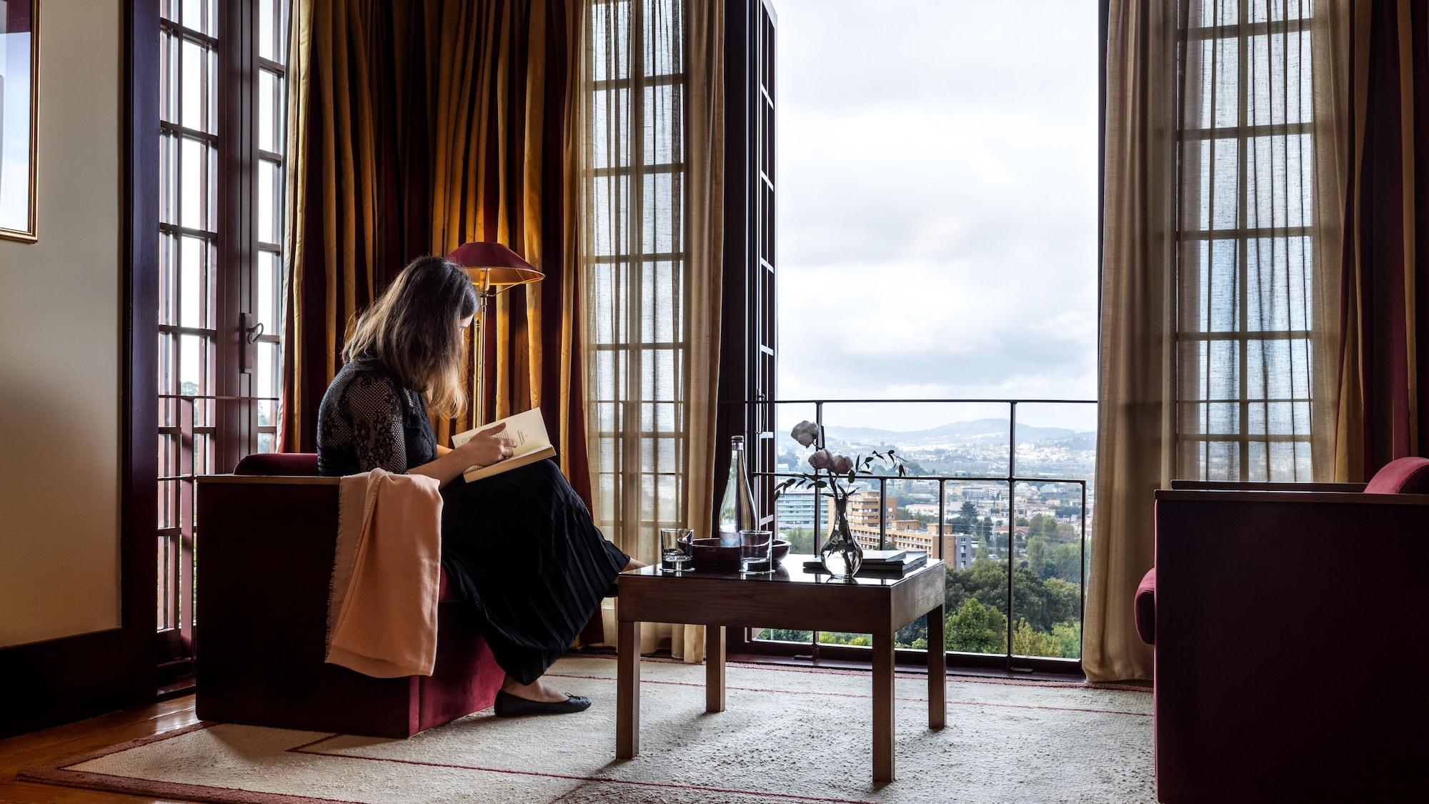 Pousada Mosteiro De Guimarães Kültér fotó A woman reading in a room